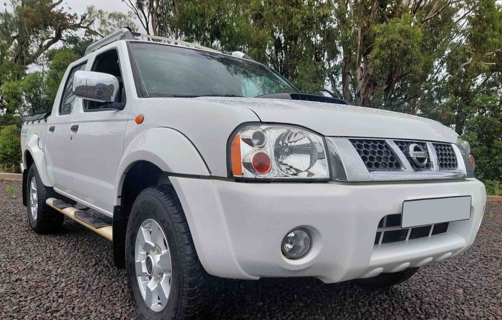 Nissan Hardbody driving on a dirt road in rural Mauritius.