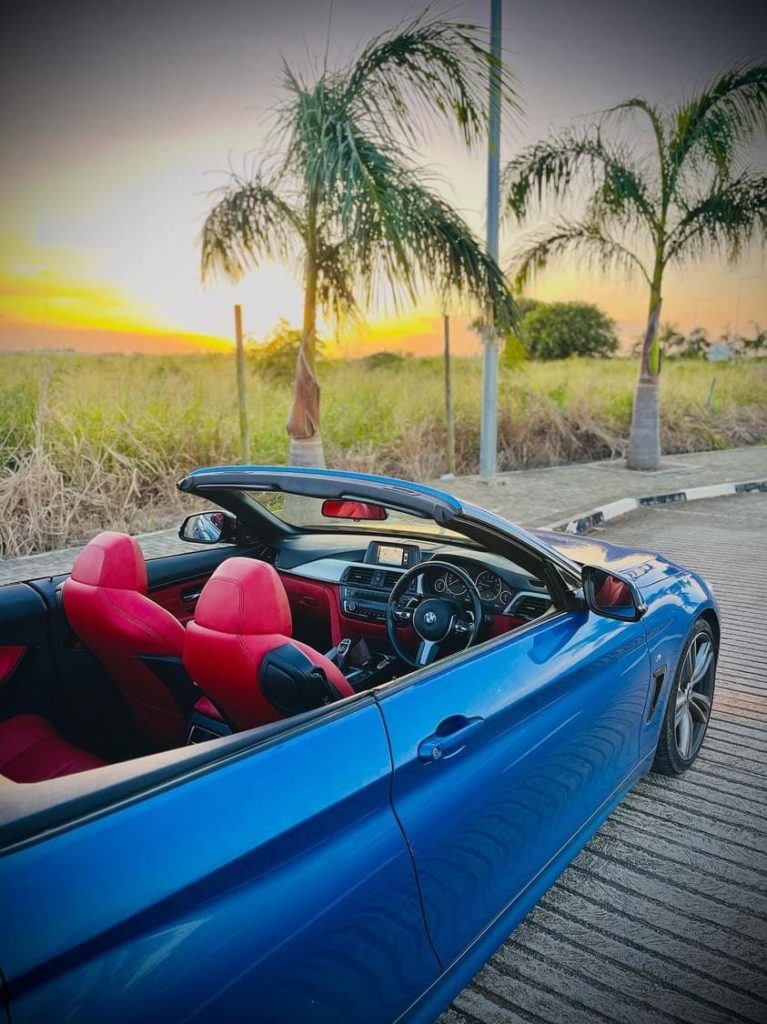 BMW 428i Convertible (Hardtop) available through peer-to-peer car sharing in Mauritius, shown parked on a seaside road under clear blue skies