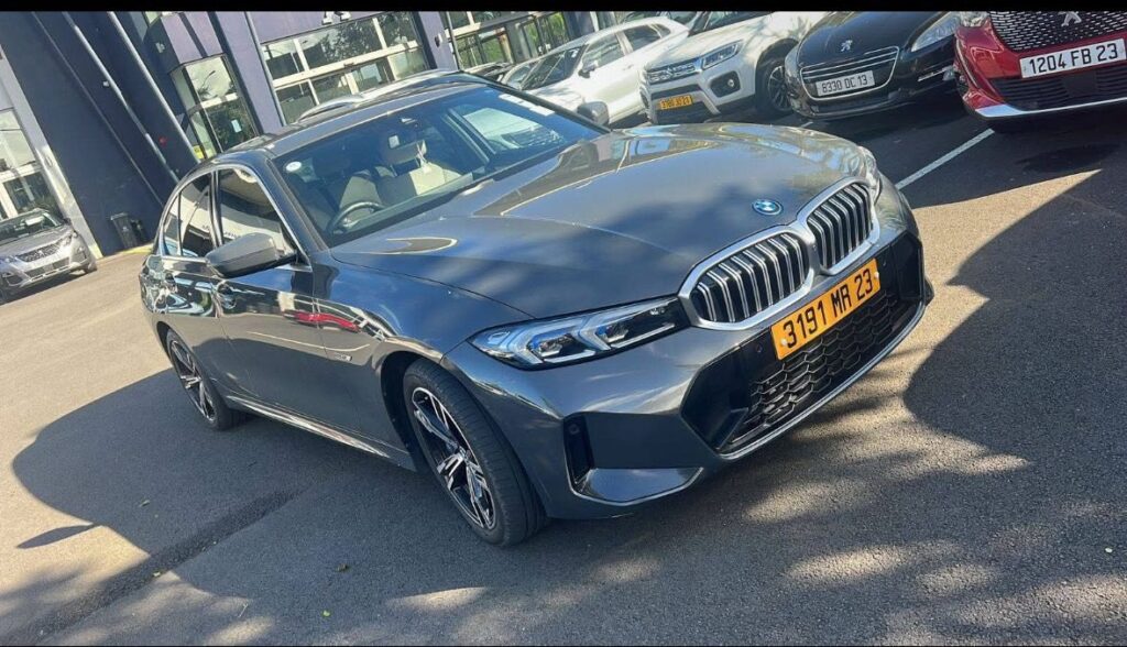 A sleek metallic silver BMW 330e parked on a scenic coastal road in Mauritius, branded with Liberta Car Rental logos to showcase their luxury car hire service