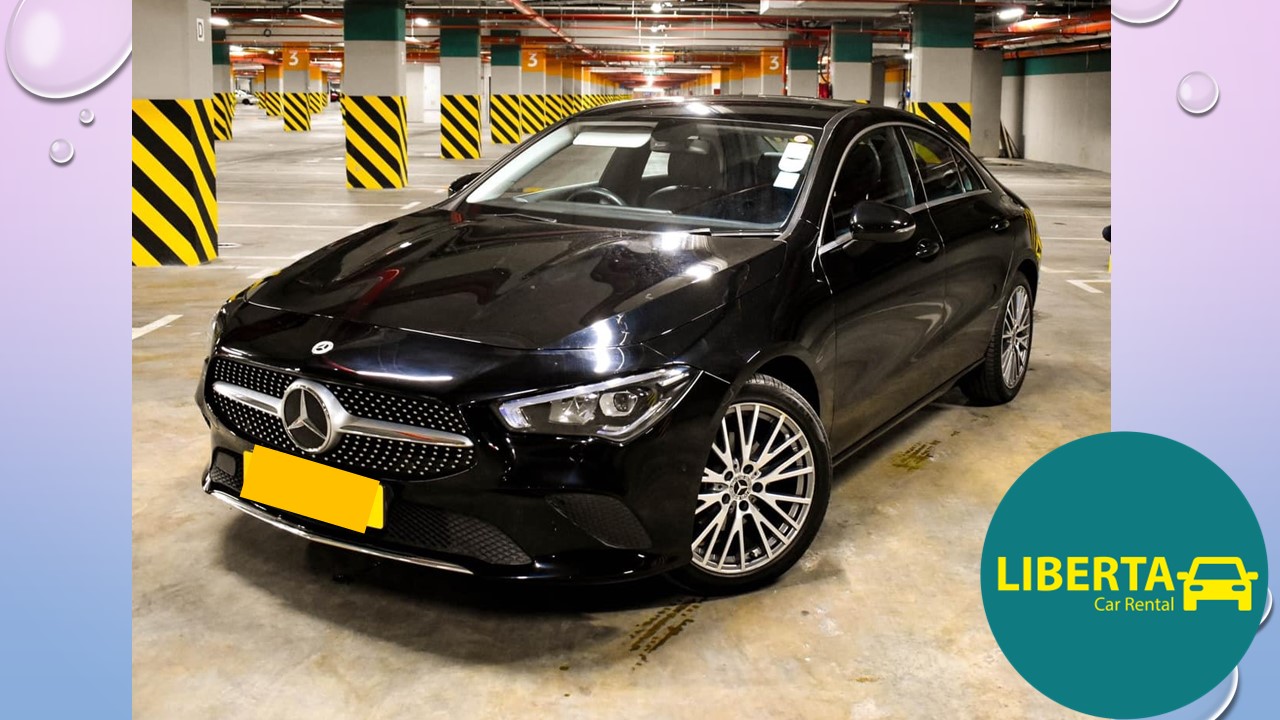 Liberta Car Rental Mauritius – Mercedes CLA (C118) luxury sedan gleaming on a scenic coastal road at sunset