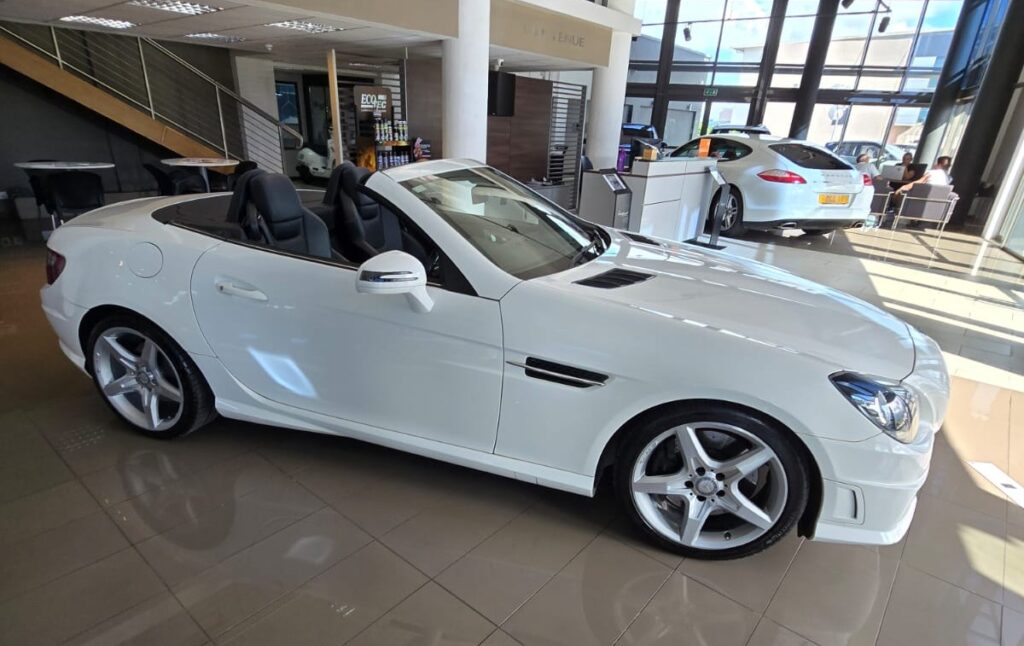 Peer to Peer Car Rental Mauritius - Mercedes‑Benz SLK200 convertible roadster with retractable hardtop parked on a scenic Mauritian coastal road.