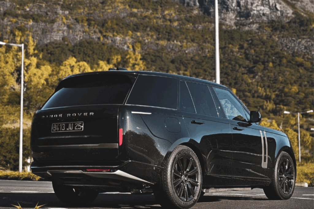 Premium SUV Rental experience – Range Rover Vogue P400 navigating a winding coastal highway with turquoise sea views